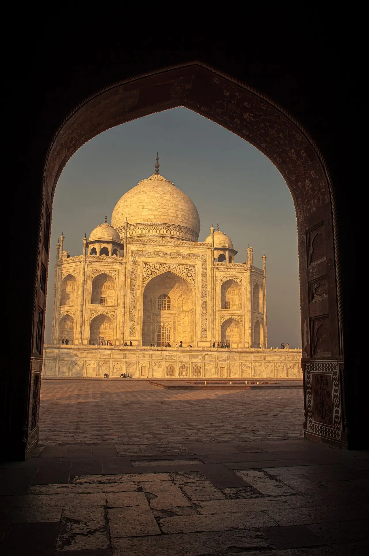 The Taj Mahal glowing through an archway