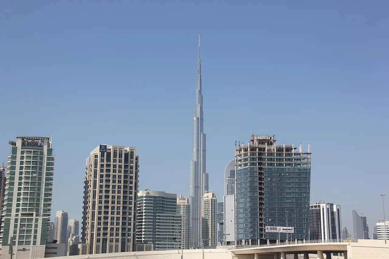 Burj Khalifa rising above the Downtown Dubai skyline under a blue sky