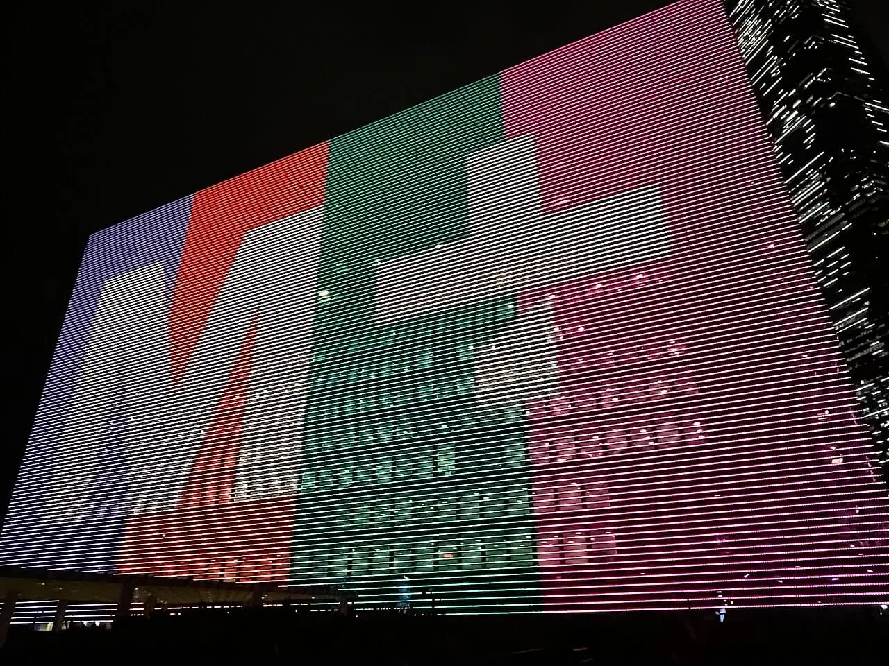 The giant LED facade of M+ lit up at night