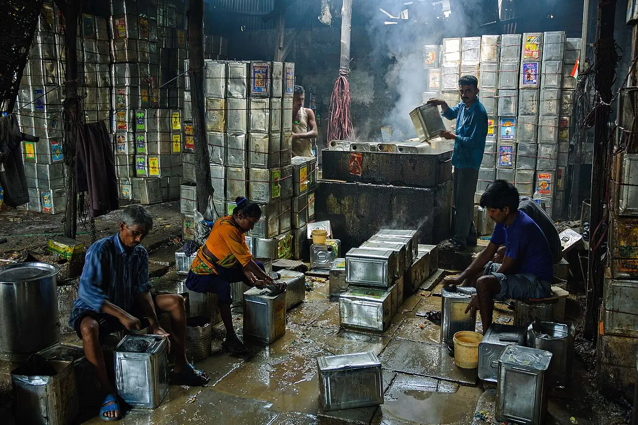 Workers cleaning metal drums for reuse in Dharavi