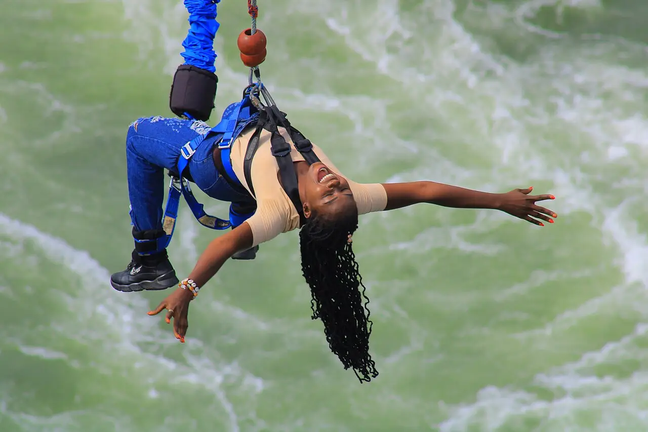 A bungee jumper swinging over a river