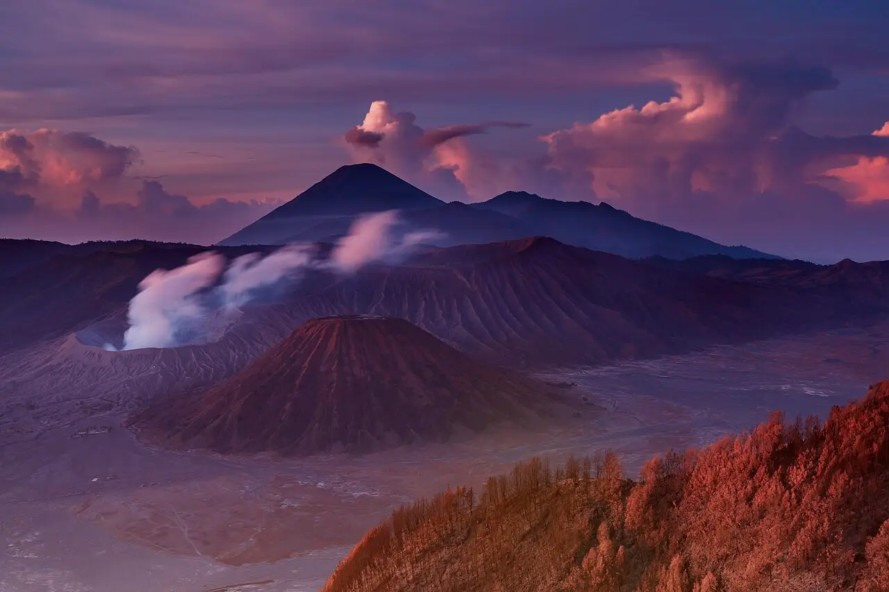 Mount Bromo smoking at sunrise, with Mount Semeru behind