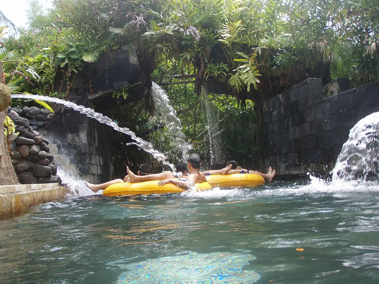 Riding a tube under the waterfalls of the lazy river at Waterbom Bali