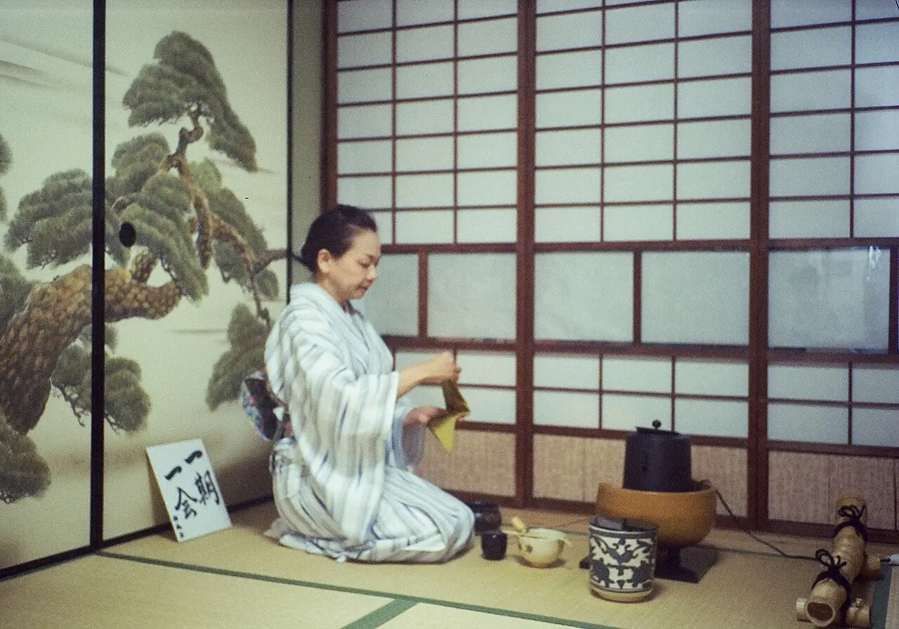 A tea ceremony host preparing matcha in a Kyoto tea room