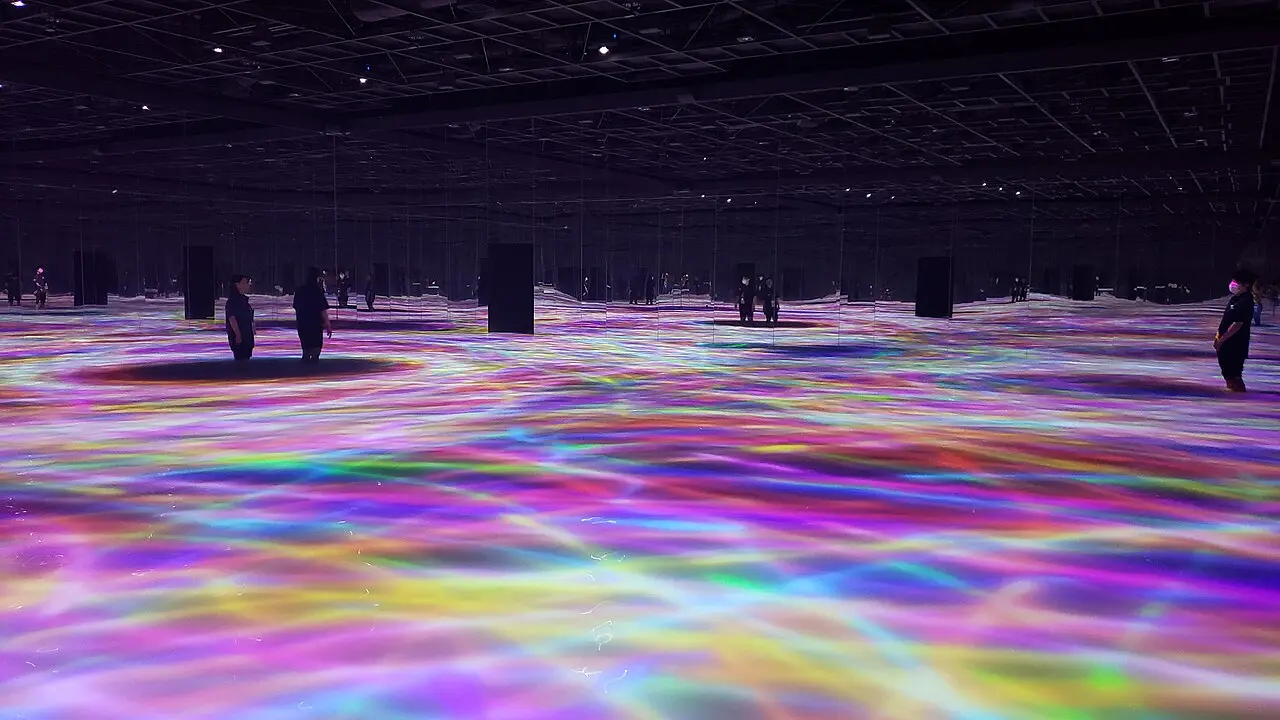 Visitors wading through a glowing water artwork at teamLab Planets