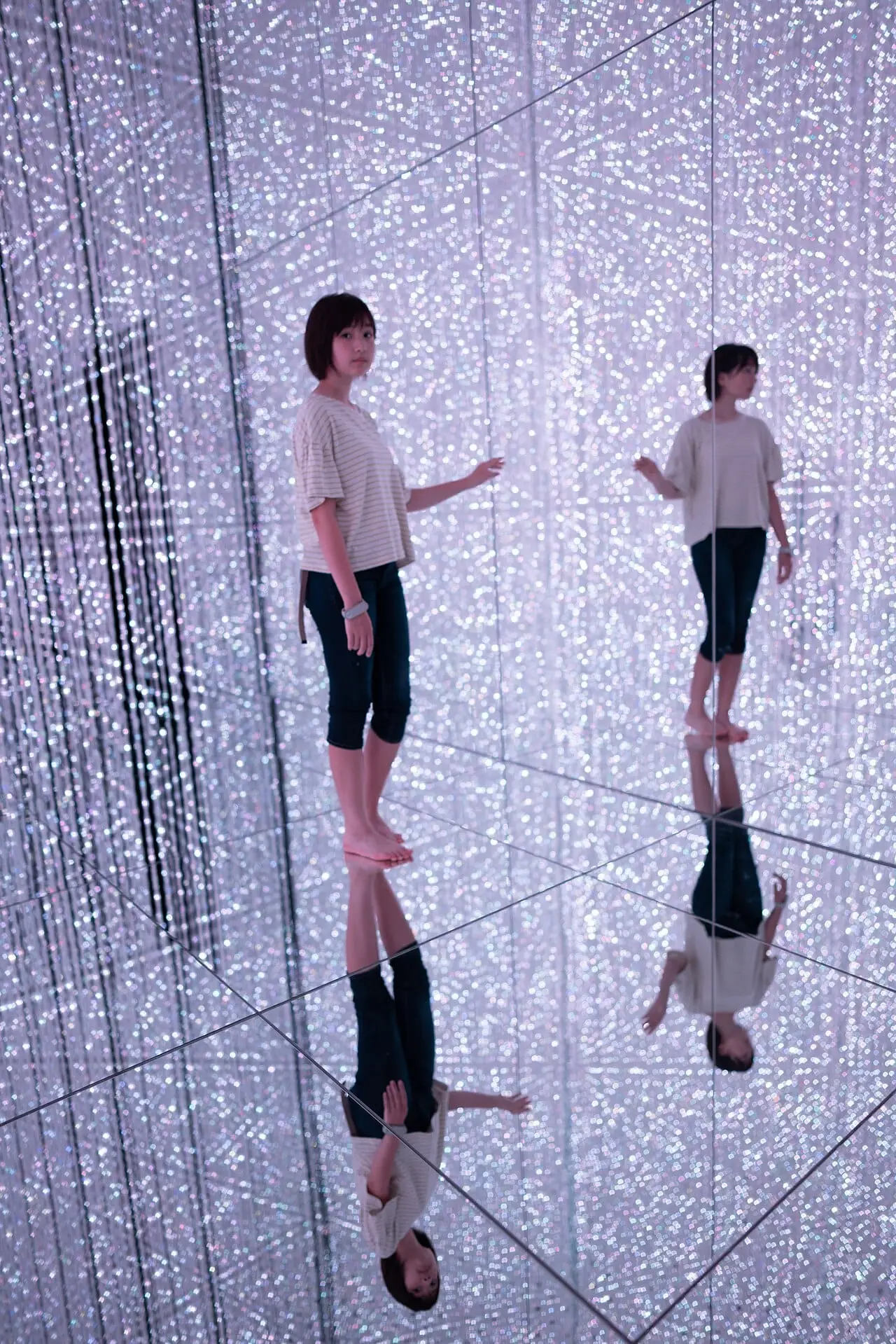 Visitors among mirrors and strings of light