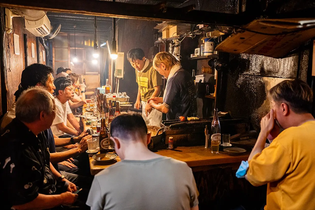 Diners at a yakitori counter in Omoide Yokocho