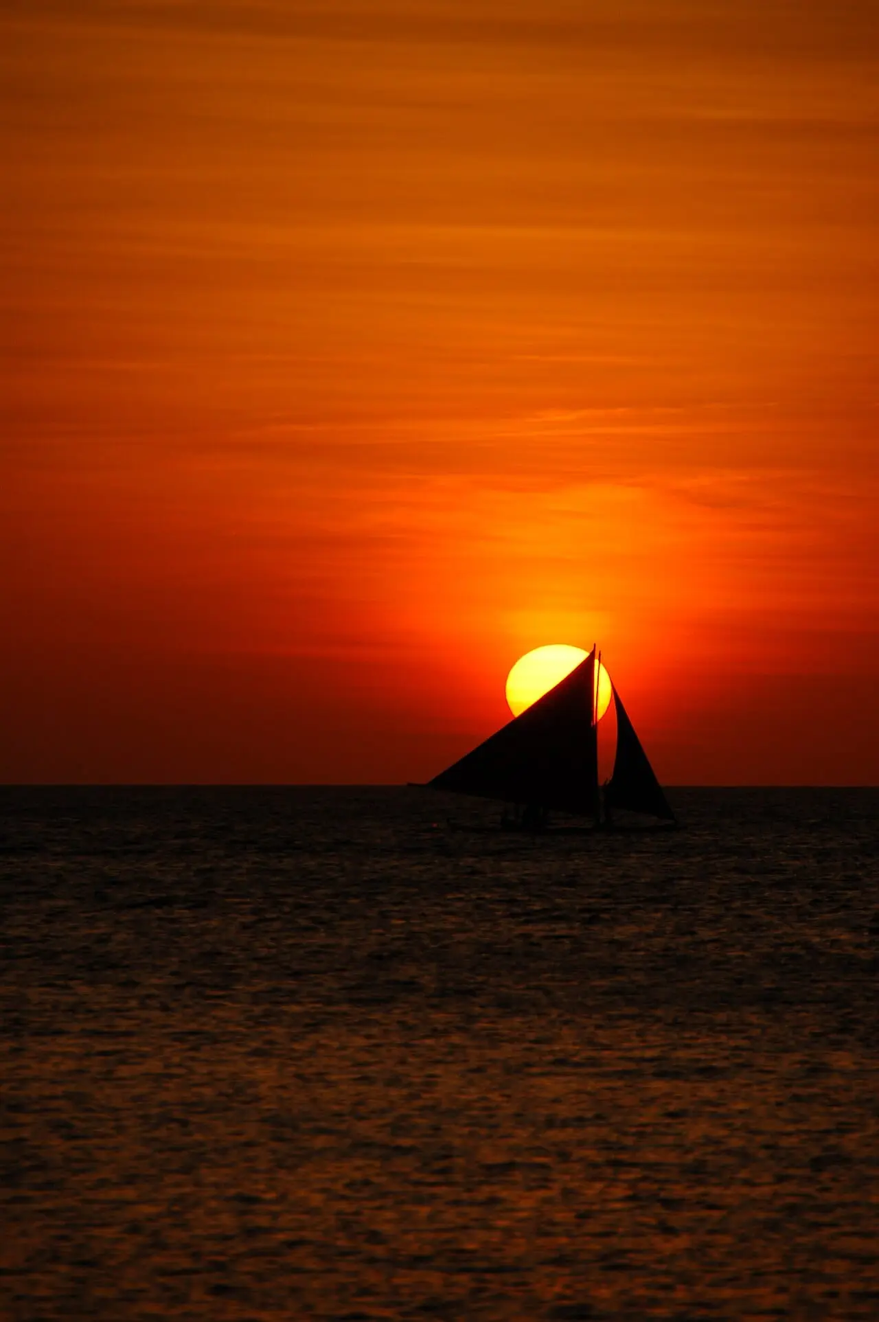 A paraw crossing the setting sun at Boracay