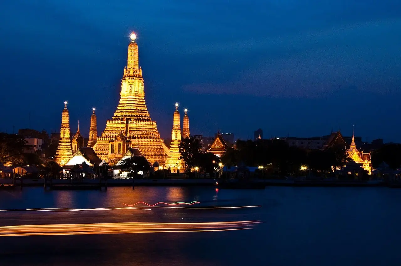 Wat Arun lit up at night beside the Chao Phraya River