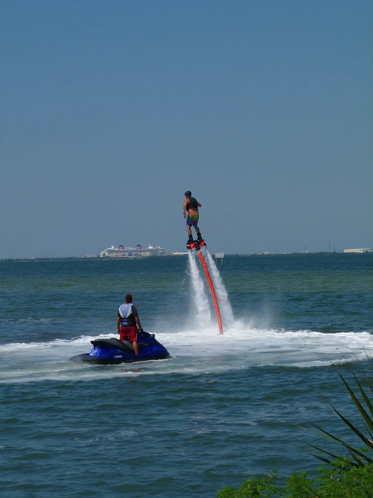 Flyboarding beside a jet ski