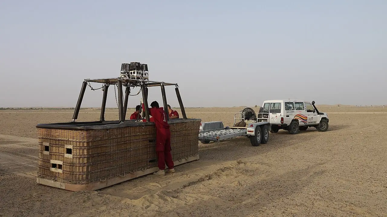A balloon basket being prepared in the desert