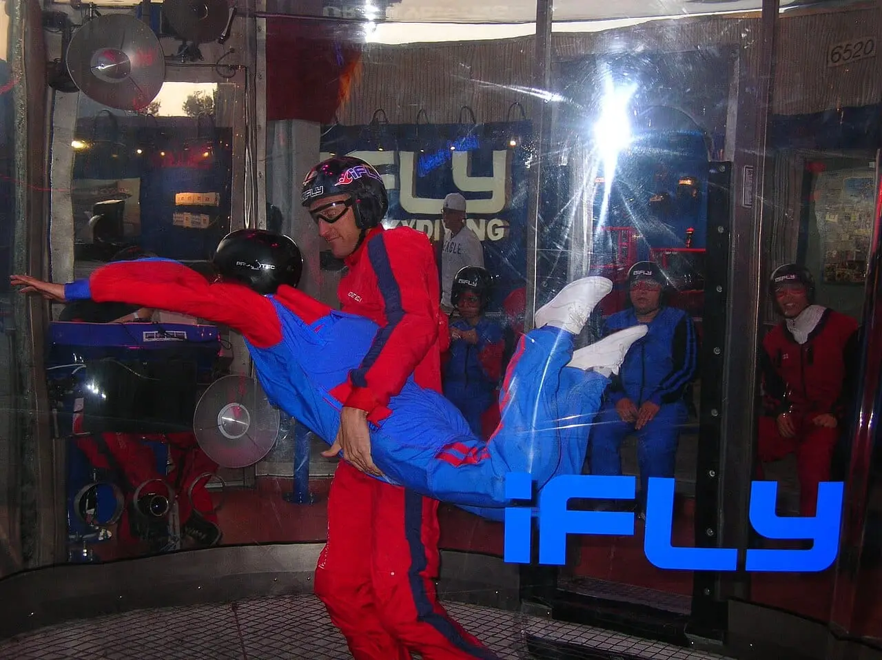 A flyer and instructor in an iFly wind tunnel