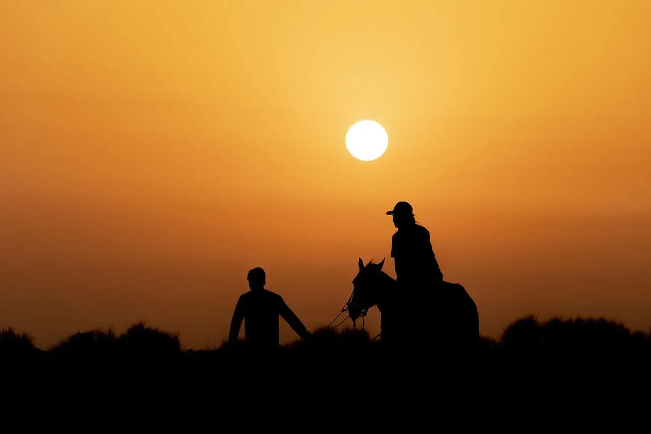 Riders on the dunes at sunset