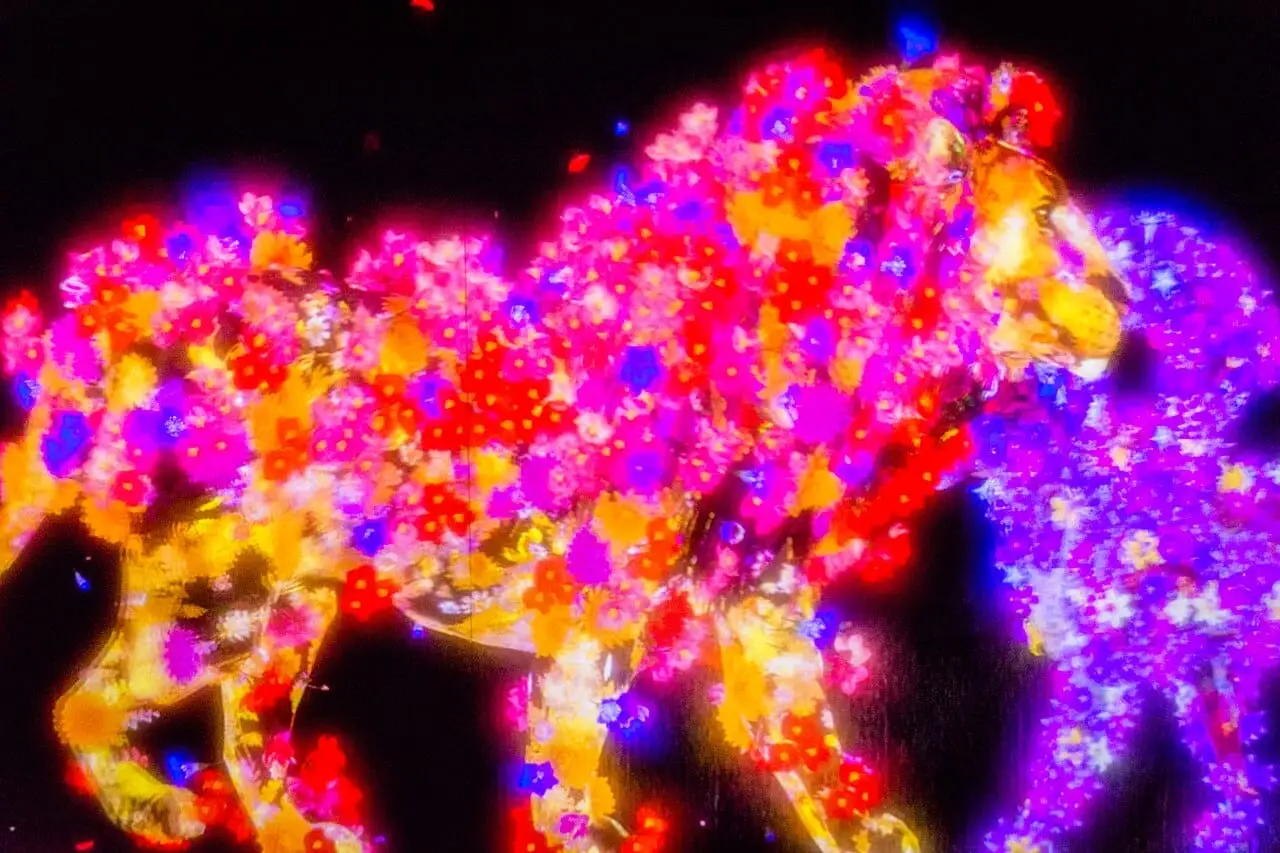 A glowing animal made of flowers in a teamLab artwork