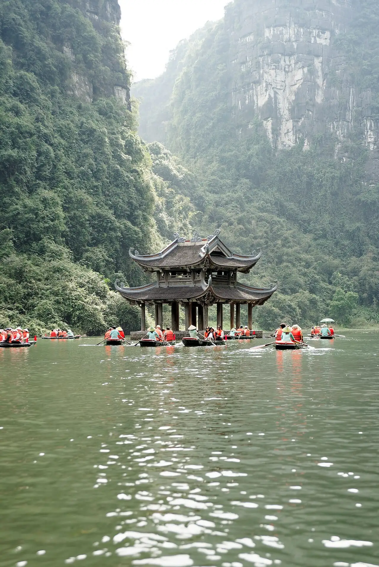 A pagoda on the water with rowing boats at Trang An, Ninh Binh