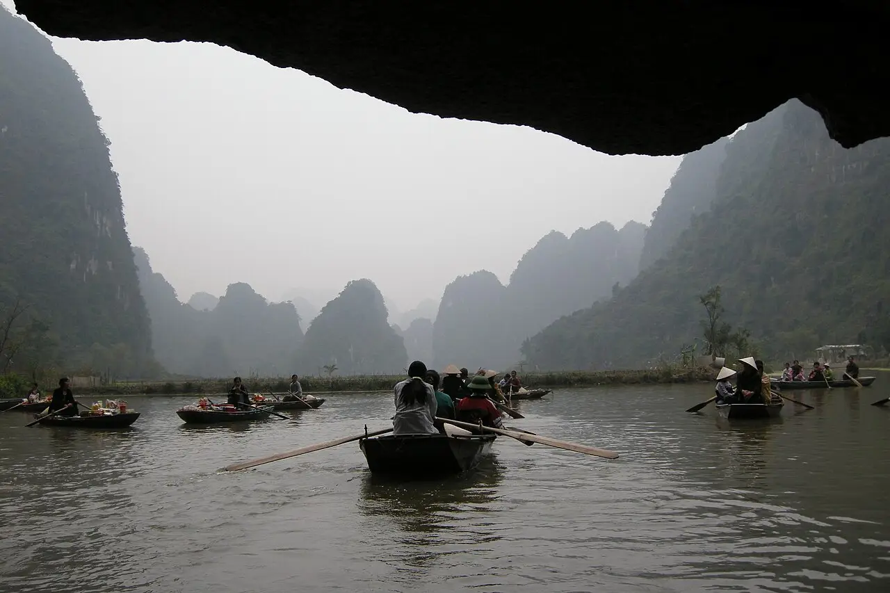 Rowing boats passing out of a cave at Trang An
