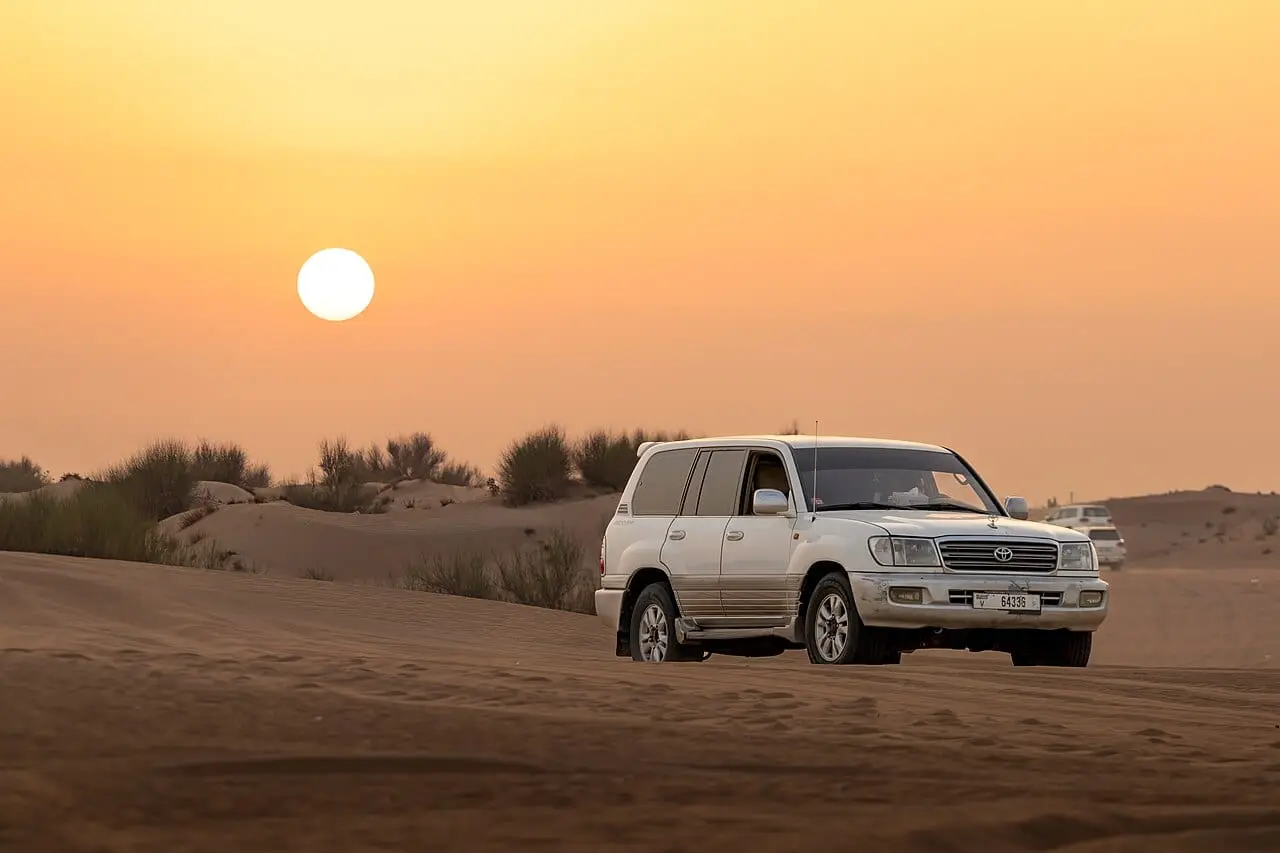 A 4x4 on the dunes at sunset on a Dubai desert safari