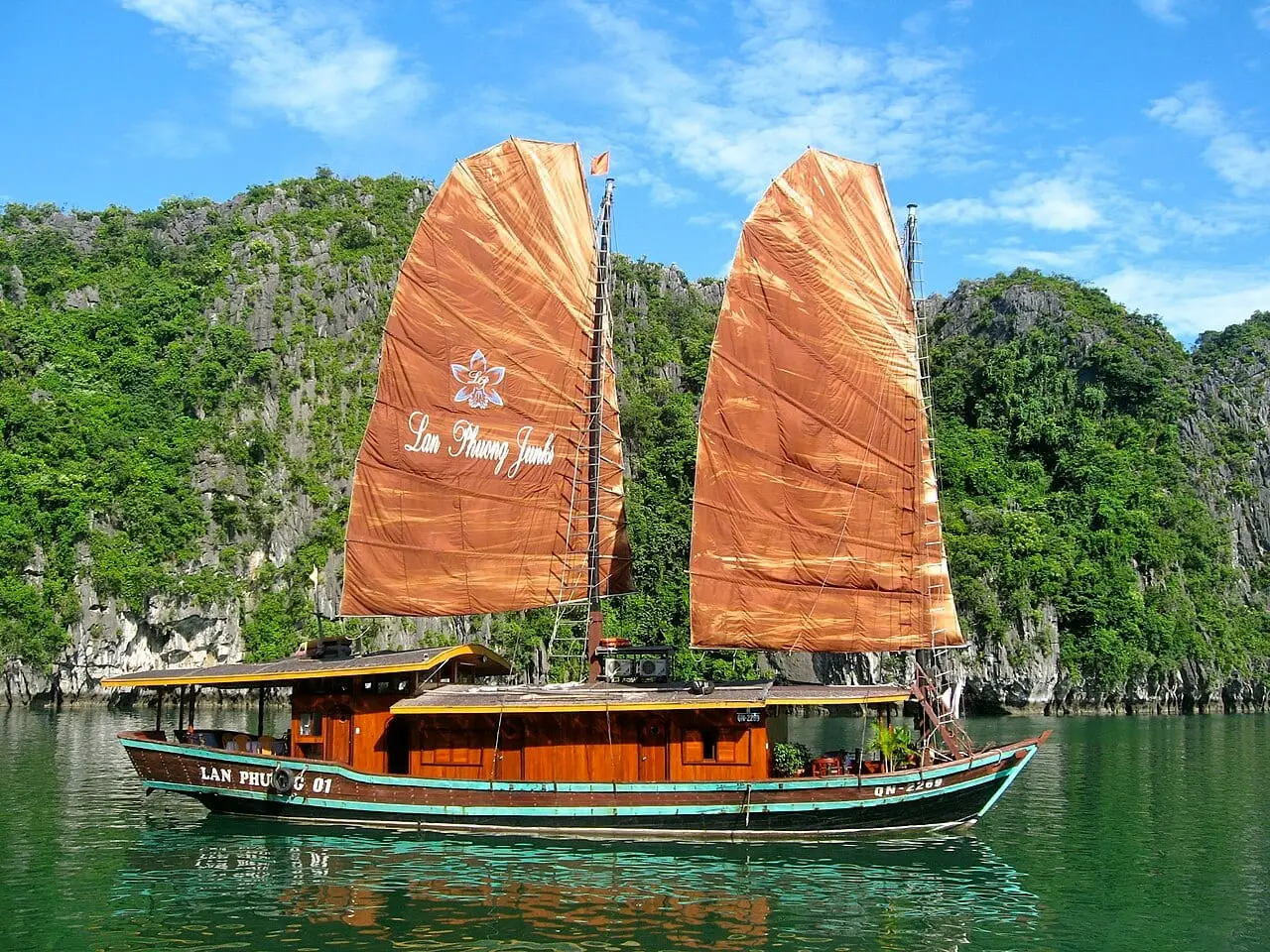 A traditional junk boat among the limestone islands of Ha Long Bay