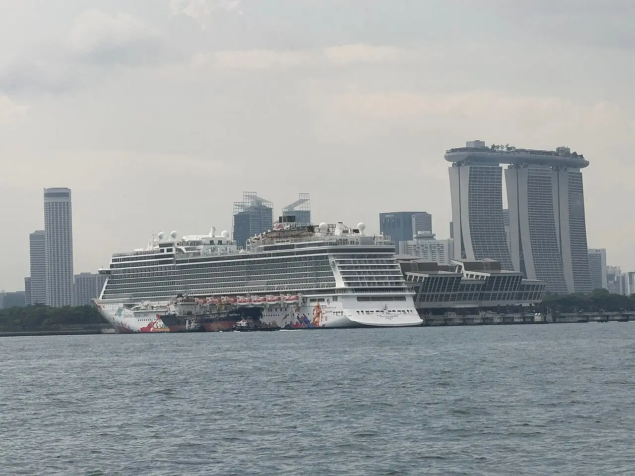The Genting Dream sailing past Marina Bay Sands