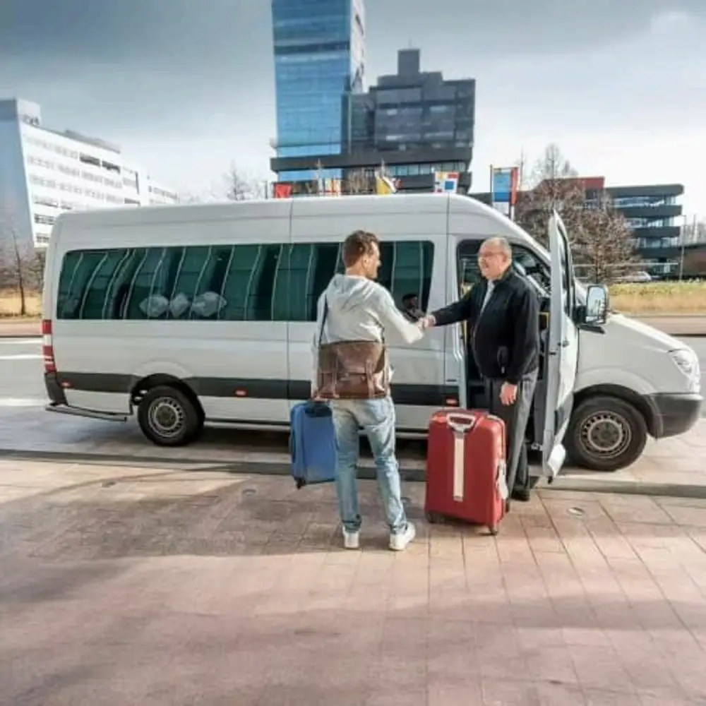 A private van and driver meeting travellers with their luggage